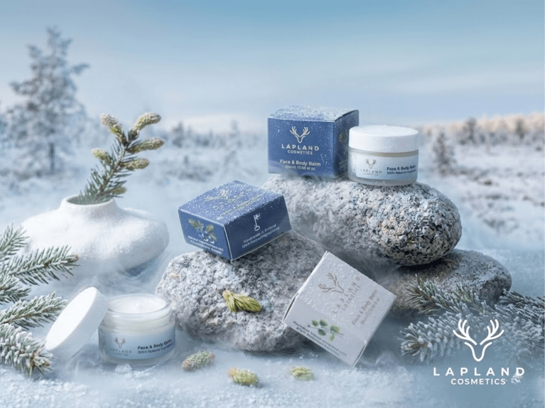 Produkty Lapland Cosmetics – balzámy v elegantních skleničkách obklopené severskými plody a bylinami (borůvky, jalovec, březová kůra) na světlém pozadí